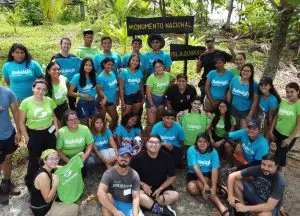 Grupo de voluntarios y voluntarias posando durante una jornada ambiental en la playa.