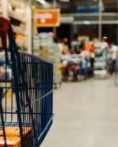 Shopping cart in supermarket aisle representing smart grocery shopping to reduce food waste