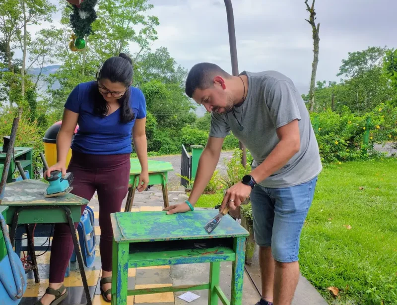 Volunteers sanding and restoring school desks during a volunteering project in a rural community in Turrialba Costa Rica